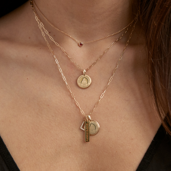 Ohio State Florentine Necklace Petite shown on figure in gold with a Link Chain with the Sunburst, Coordinates Bar, Diamond Initial Charm on Link Chain, and the Garnet Gemstone Necklace shown in gold