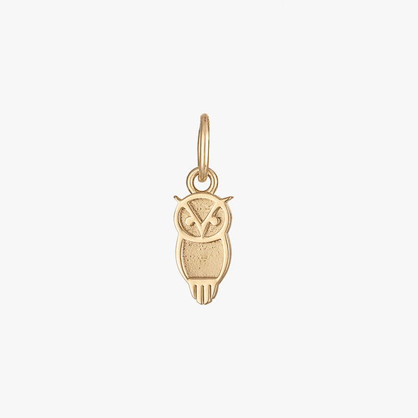 A gold owl charm with a logo on it, suspended by a loop.
