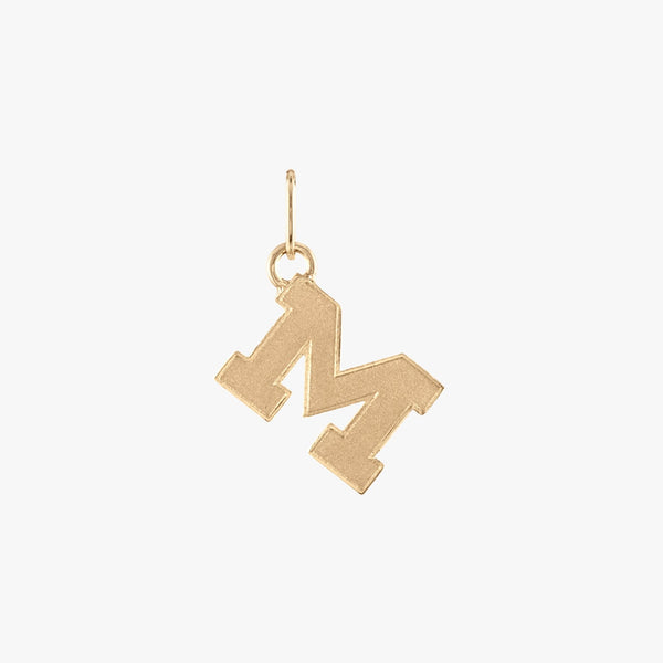 A gold Michigan M letter charm with a satin finish.