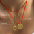 Close-up of a person's neck wearing layered gold necklaces with orange cords and small pendants, with overlaid text labels identifying the chain styles and cord lengths.