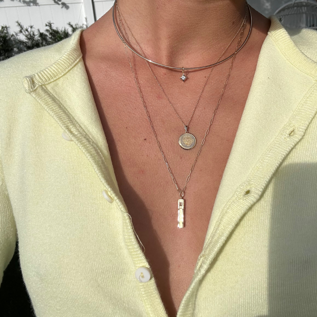 Florida Seal Sunburst Pendant shown on figure in gold on Cable Chain with Florida Century Tower on long Link Chain in gold with North Star Charm on Neck Collar in gold