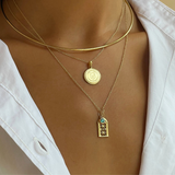 Georgetown Visitation Sunburst shown on figure in gold on Cable Chain with Georgetown Visitation Small Gate on Cable Chain in gold with Emerald Gemstone Charm and Neck Collar
