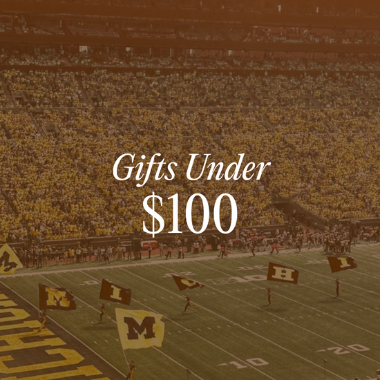 Gifts Under $100 graphic linking to collection of Gifts Under $100 with background of Michigan Big House Stadium
