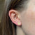 Alpha Chi Omega Lyre Stud Earring shown on figure in gold