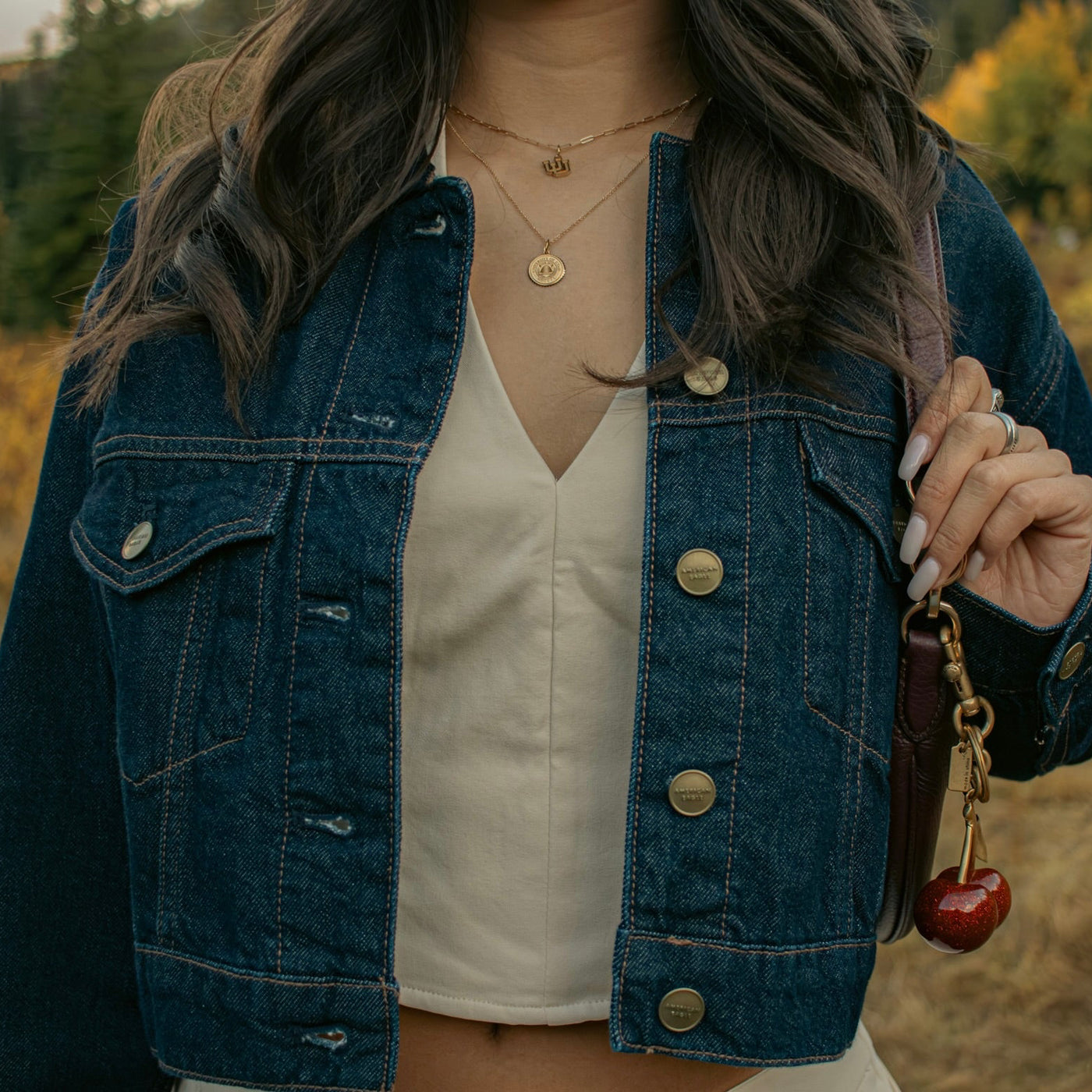 Utah Logo Charm shown on figure in gold on Link Chain with Utah Sunburst Pendant in gold on Cable Chain