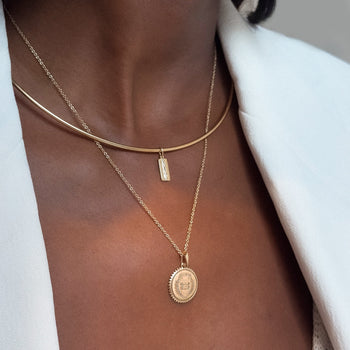 North Star Line Bar Charm shown on figure in gold on Neck Collar with Yale Sunburst Pendant on Cable Chain