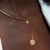 North Star Disc Charm shown on figure in gold on Neck Collar with UGA Sunburst Pendant on Cable Chain