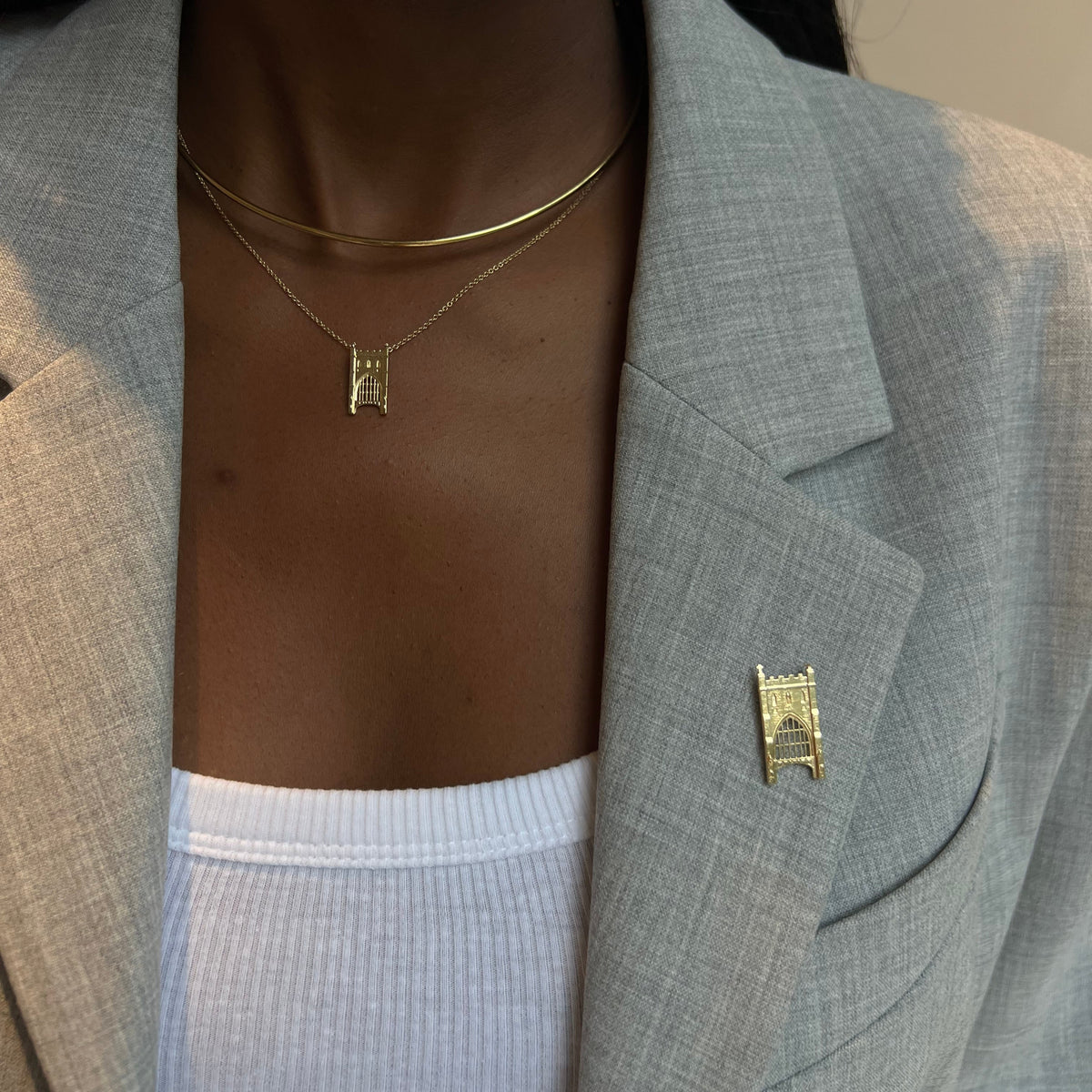 Notre Dame Law School Lapel Pin shown on figure in gold with Notre Dame Law School Pendant on Cable Chain with Neck Collar
