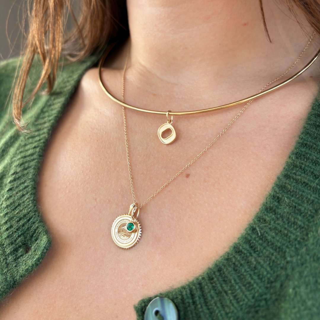 Oregon Logo Charm shown on figure in gold on Neck Collar with Oregon Sunburst Bundle in gold