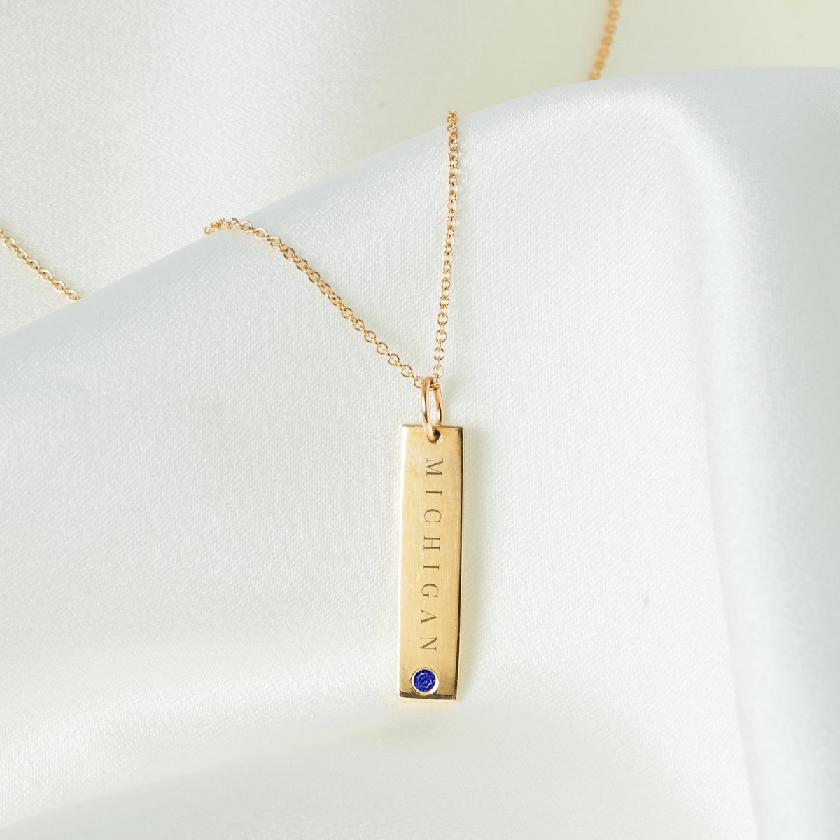Michigan Sapphire Gemstone Bar laydown shown in gold on cable chain