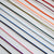 A close-up of multiple thin cords or threads arranged diagonally on a white background, shown in several colors including black, purple, pink, blue, green, orange, and red.