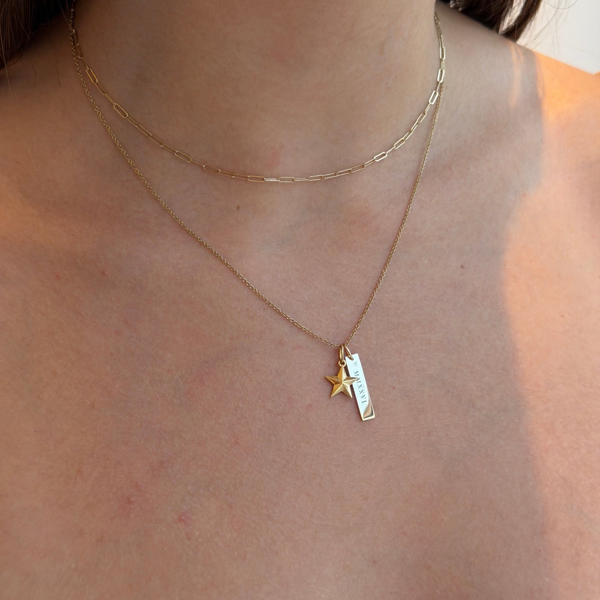 Gold necklace with a star pendant on a person's neck