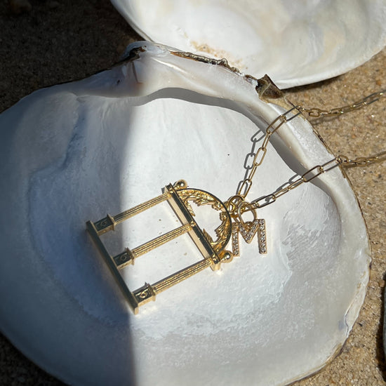 Gold necklace with a pendant on a white shell