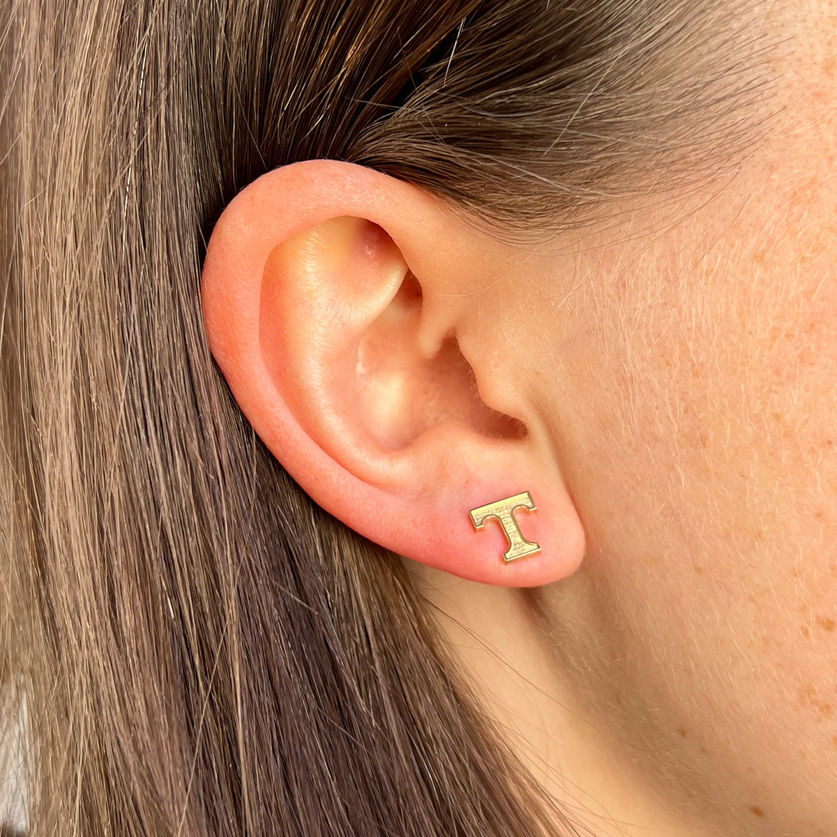 Tennessee T Stud shown on figure in gold in size 8mm