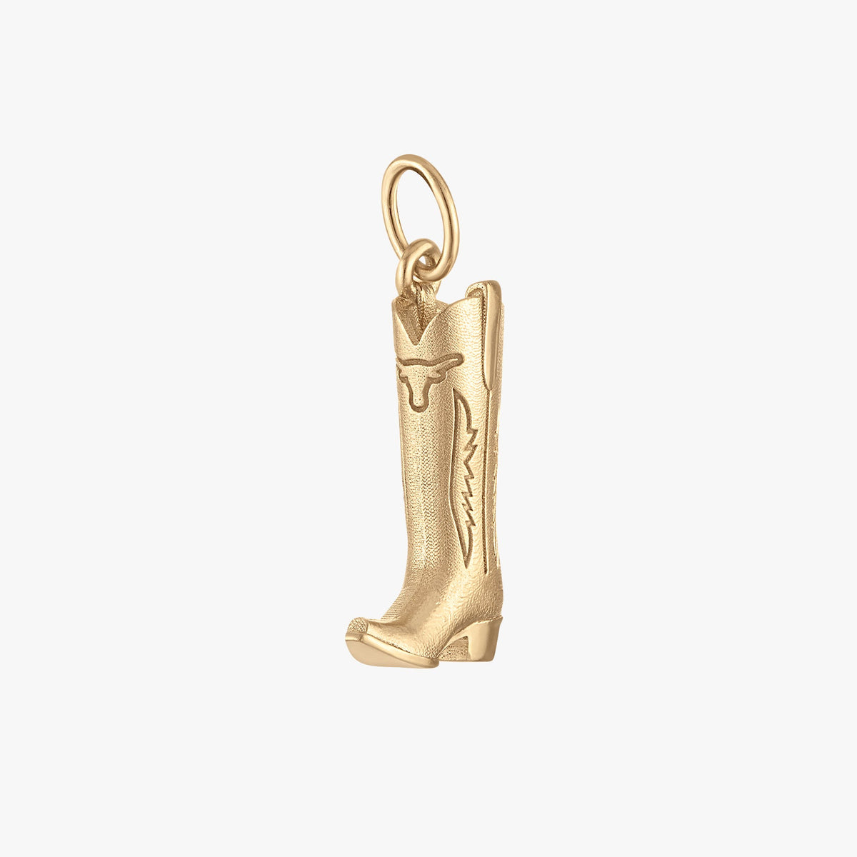 A small gold cowboy boot charm pendant with engraved decorative details, shown on a plain light gray background.