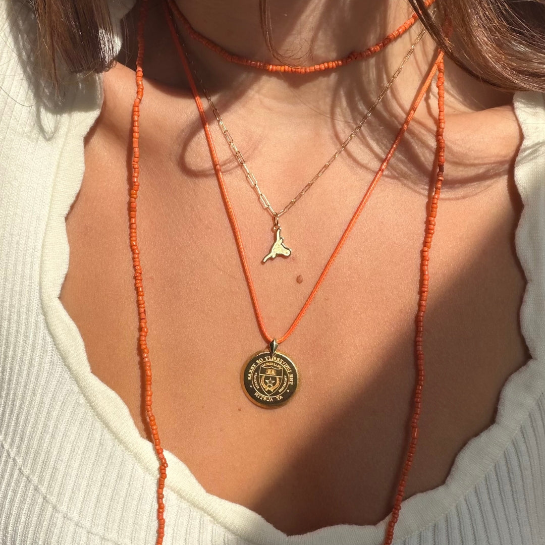 UT Longhorn Charm shown on figure on Link Chain with Large UT Florentine Pendant on figure in gold on Orange Rope Chain with Orange Beads