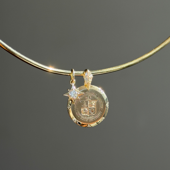 Gold necklace with a pendant on a dark gray background