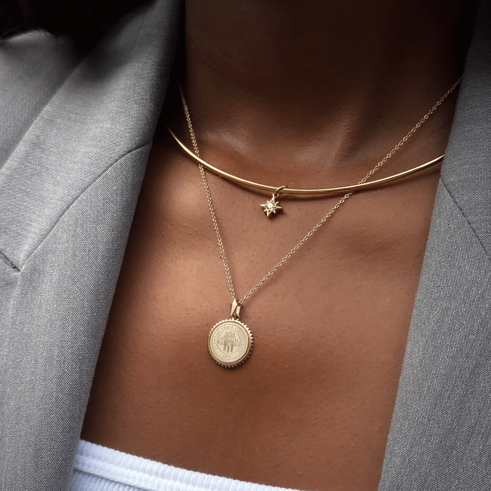 North Star Charm shown on figure in gold on Neck Collar with FSU Sunburst on Cable Chain